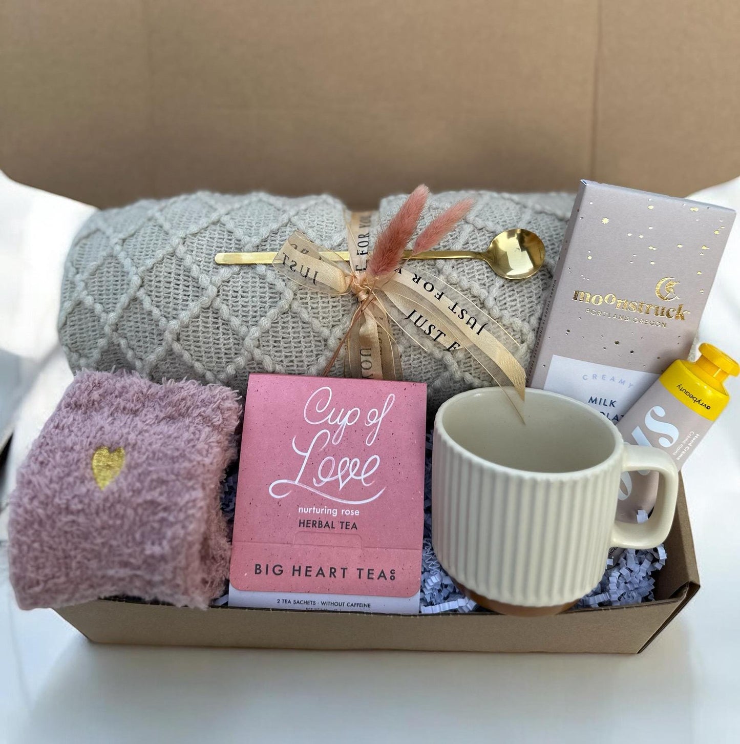 a gift box with a cup, mug, and other items
