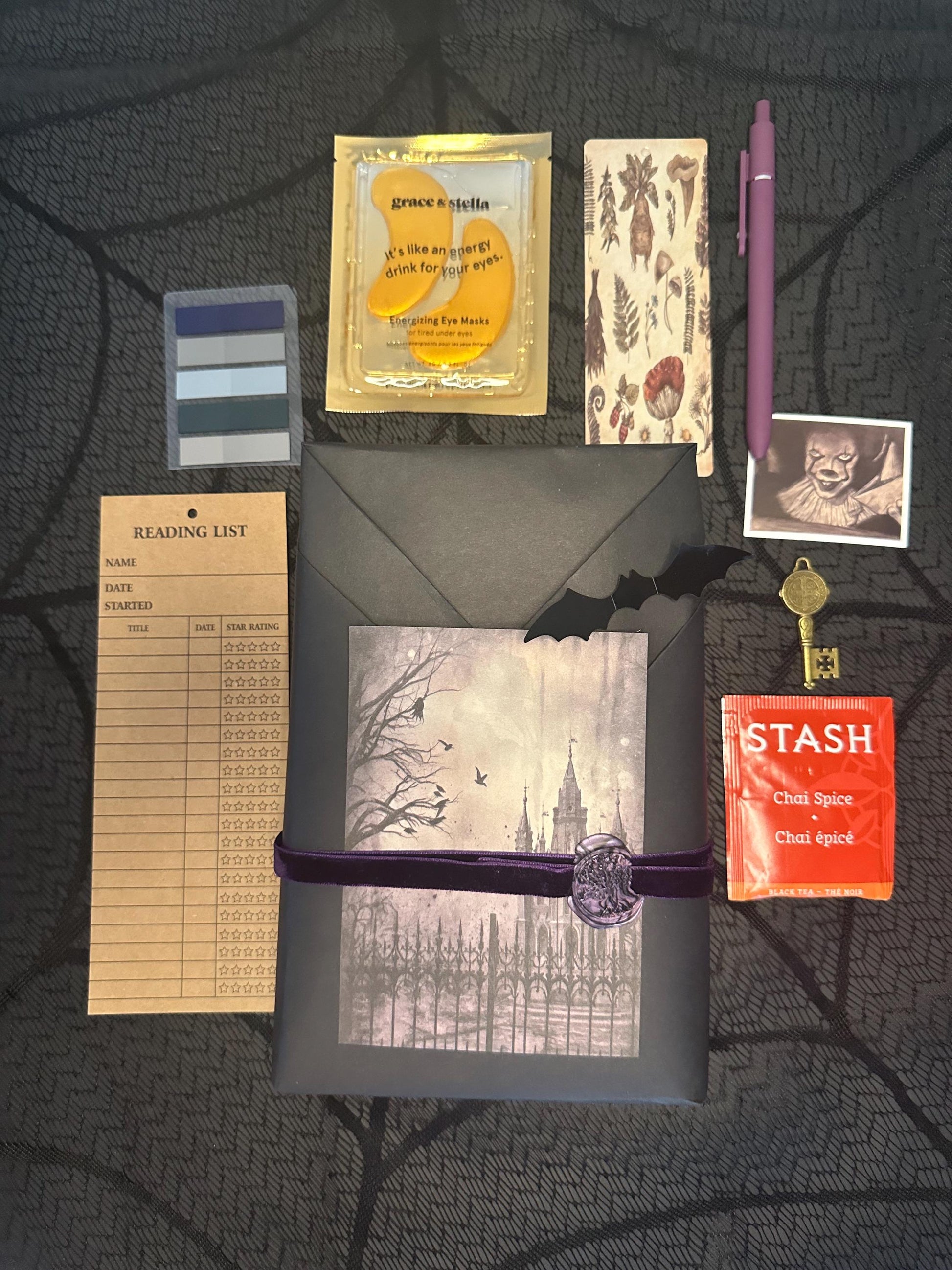 a table topped with a notepad, pen, envelope and other items