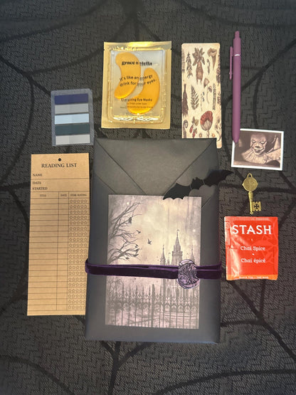 a table topped with a notepad, pen, envelope and other items
