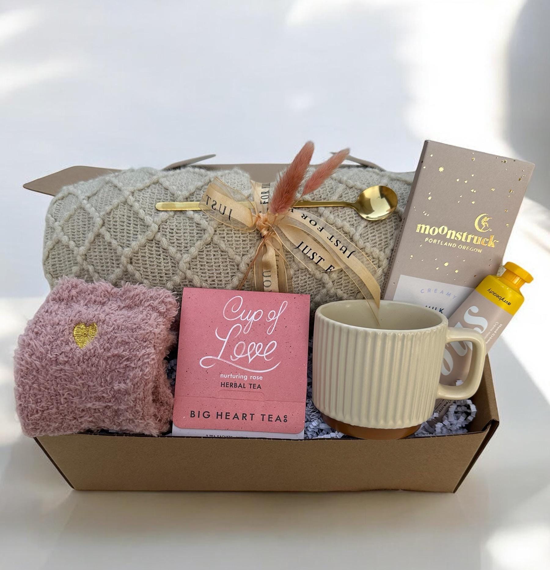 a box with a cup of coffee and a blanket