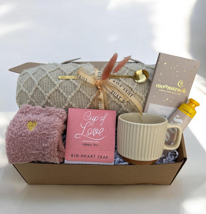 a box with a cup of coffee and a blanket
