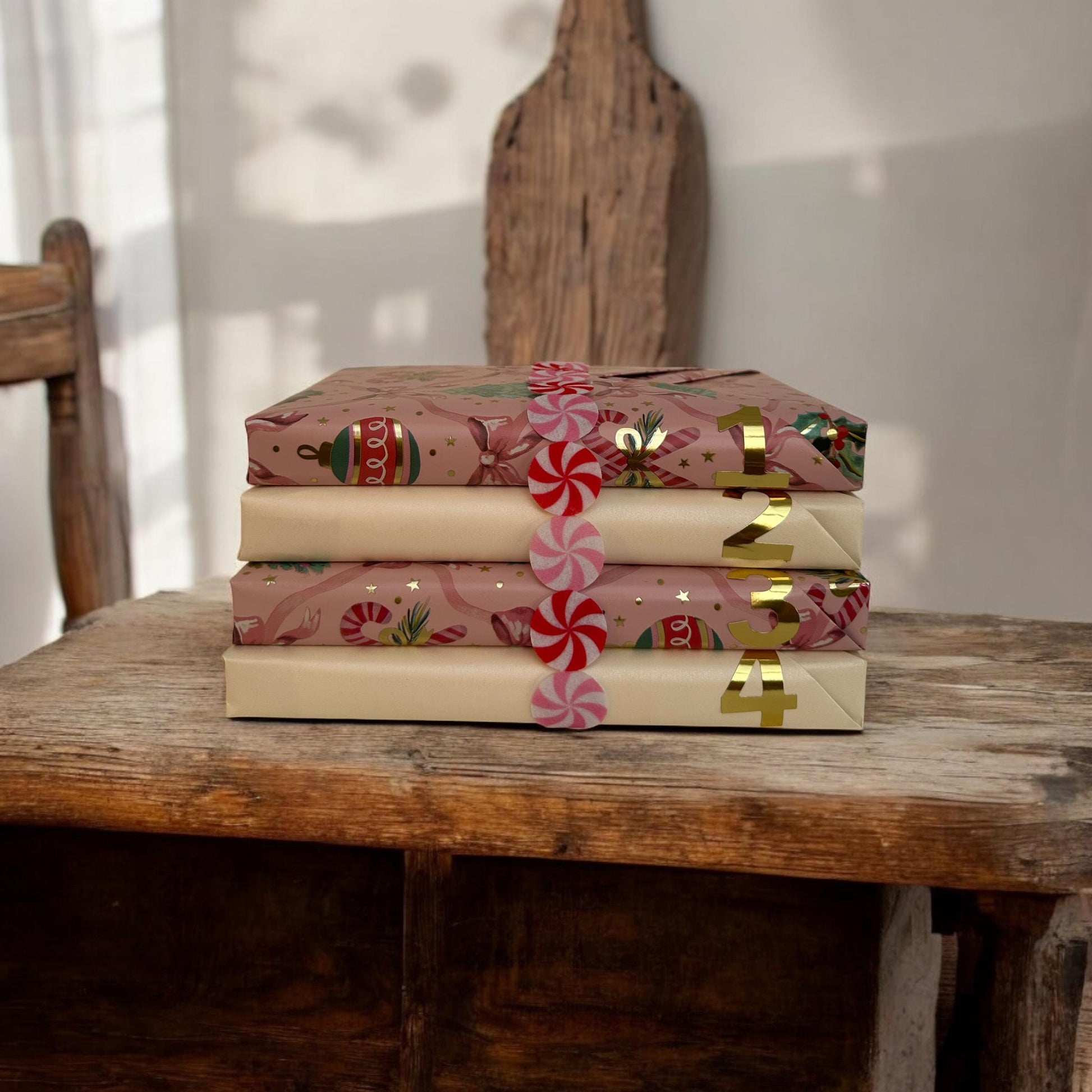 a stack of three wrapped presents sitting on top of a wooden table