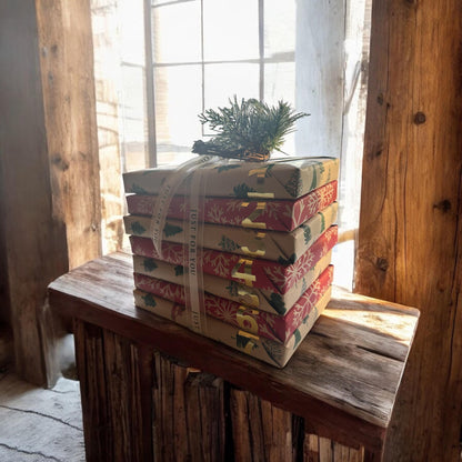 a stack of wrapped presents sitting on top of a wooden table